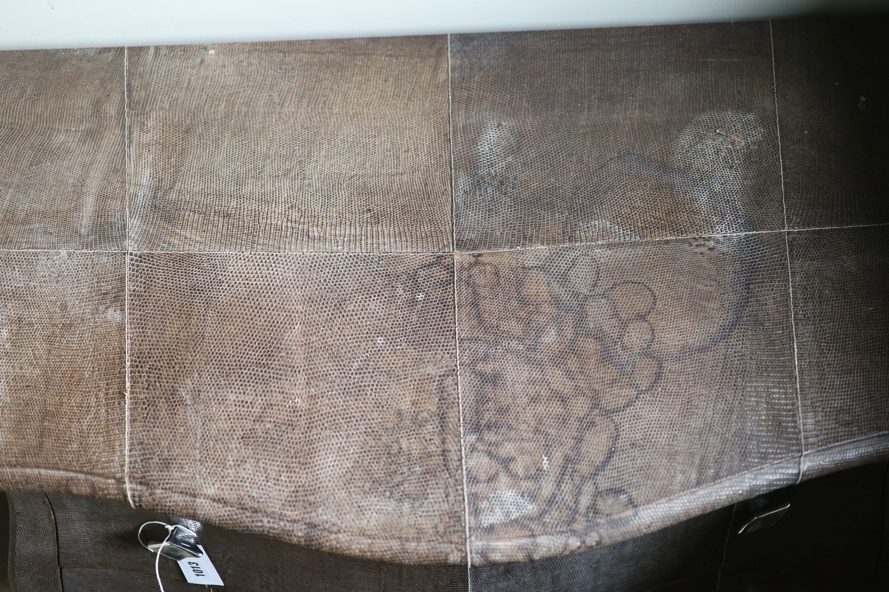 A three drawer bombe commode, upholstered in simulated snake skin, width 102cm depth 51cm height 88cm